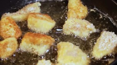 Yemek hazırlama. Kızartma makinesinde tavuk nugget hazırlığı. Kızarmış tavuğu kızgın yağda kızartma işlemi.