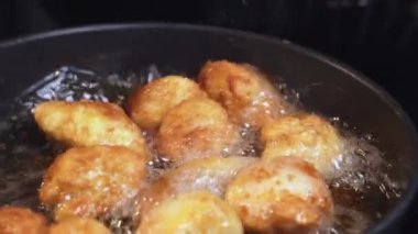 Yemek hazırlama. Kızartma makinesinde tavuk nugget hazırlığı. Kızarmış tavuğu kızgın yağda kızartma işlemi.