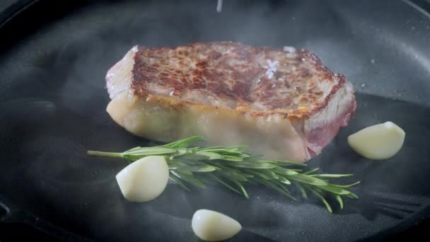 Steak Auf Einer Gusseisernen Pfanne Mit Kräutern Und Knoblauch Essenszubereitung — Stockvideo