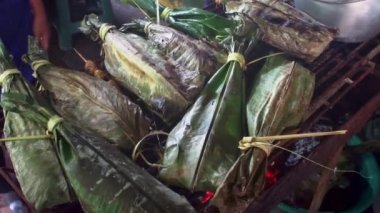 Ekvador 'da, El Coca olarak da bilinen Puerto Francisco de Orellana' da sokak yemekleri. Satılık muz yapraklarına sarılı Tilapia balığı. Yüksek kaliteli FullHD görüntüler
