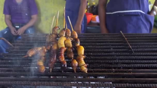 烤棕榈幼虫在绞架上 沙哥甲虫厄瓜多尔街头食品 — 图库视频影像
