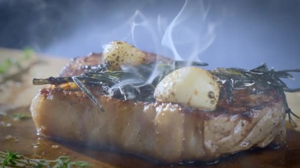 烤制的牛排放在木制切菜板上 锅里新鲜的肉 用大蒜和迷迭香煎肉 准备食物 慢动作100Fps 4K视频 — 图库视频影像