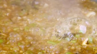 Soğanları yakın plan kaynatın, kereviz sapları, sarımsak, biberiye bir tavada spagetti, makarna. 4KSlow motion video. Yüksek kalite 4k görüntü