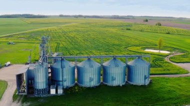 Uçsuz bucaksız tarım arazileri, modern tahıl deposu ve kurutma tanklarıyla hava manzarası. Modern silolar. Yüksek kalite 4k görüntü