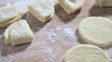 Yemek hazırlama. Süzme peynirli kurabiye yapıyorum. Aşçı pişirmeden önce kurabiyeleri şekere sarar ve onları mutfak tahtasına koyar. Yavaş çekim videosu 100fps. Yüksek kaliteli FullHD görüntüler