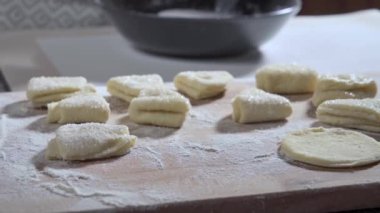 Yemek hazırlama. Süzme peynirli kurabiye yapıyorum. Aşçı pişirmeden önce kurabiyeleri şekere sarar ve onları mutfak tahtasına koyar. Yavaş çekim videosu 100fps. Yüksek kaliteli FullHD görüntüler