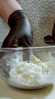 Kadın elleri hamur, peynir, yumurta ve tereyağı yoğurarak süzme peynirli kurabiye yapıyor. Hamur karıştırmak için cam kase. Yavaş çekim 100fps.