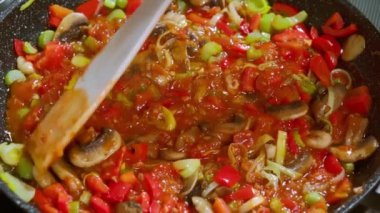 Yemek hazırlama. Makarna için sos tavada kaynıyor. Domates ezmeli makarna sosu, kereviz, pırasa, domates, mantar, dolmalık biber. Seçici odak.