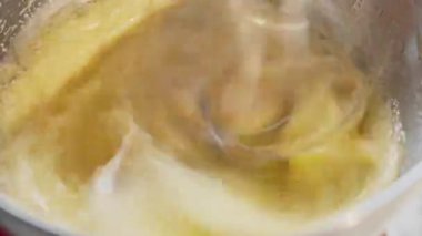 Yemek hazırlama. Mutfak mikseri çalışıyor ve yumurtayı şekerle çırpıyor. Tatlı yemek. Yavaş çekim 50 fp. Yüksek kalite 4k görüntü
