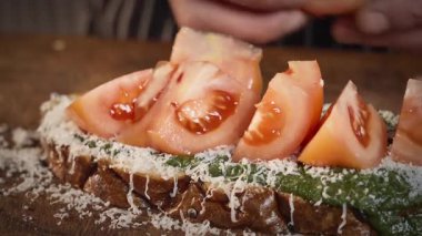 Yemek hazırlama. Şef pesto, domates ve peynirli sandviç hazırlıyor. Yavaş çekim 50 fp. Yüksek kalite 4k görüntü
