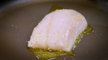 Yakın plan, yemek hazırlama. Beyaz balıklara yakın çekim, turna balığı, sıcak tavada kızarma. Yavaş çekim videosu 100fps.