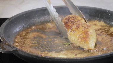Şef tavada bir parça tavuk filetosu kızartıyor. Yüksek kalite 4k görüntü