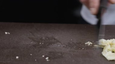 Şef, dilimlenmiş soğanları tahta kesme tahtasına itmek için bıçak kullanır. Yavaş çekim 100 fp. Yüksek kalite 4k görüntü