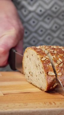 Aşçı kereviz saplarını tahta tahtada dilimlemek için mutfak bıçağı kullanıyor..