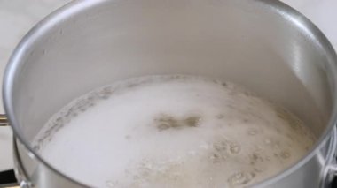 Yemek hazırlama. Yakın çekim, makarna, kaynar suda pişen spagetti. Yavaş çekim 100 fp. Yüksek kalite 4k görüntü