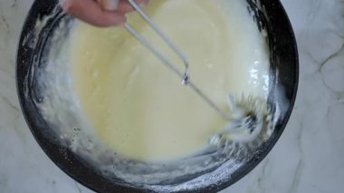 Yemek hazırlama. Üst manzara, ince krep yakın çekim, krep hamuru hazırlama. Yavaş çekim 100 fp. Yüksek kalite 4k görüntü