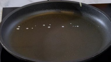 Yemek hazırlama. İnce krep yakın çekim, krep pişirme. Aşçı sıcak tavaya sıvı krep hamuru döker. Yavaş çekim 100 fp. Yüksek kalite 4k görüntü