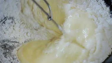 Yemek hazırlama. Üst manzara, ince krep yakın çekim, krep hamuru yapmak. Hamur suyunu koyu bir kasede karıştır. Yavaş çekim 100 fp. Yüksek kalite 4k görüntü