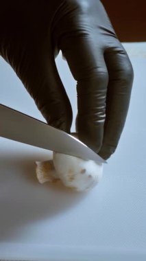 Yemek hazırlama. Kesme tahtasındaki taze şampiyon mantarlarını kesmeye yakın çekim. Seçili odak. Yavaş çekim 100 fps. Yüksek kalite 4k görüntü