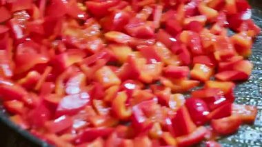 Bir şef tavada kızarırken kırmızı biber karıştırır. Yavaş çekim videosu 100fps. Yüksek kaliteli FullHD görüntüler