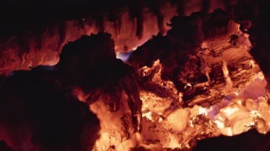Kamp ateşinde parlayan kömürlerin yakın çekimi. Sesli video. Yüksek kalite 4k görüntü