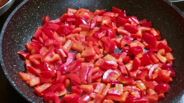 Tavada kızaran kırmızı dolmalık biberlere tuz ekliyorum. Yüksek kaliteli FullHD görüntüler