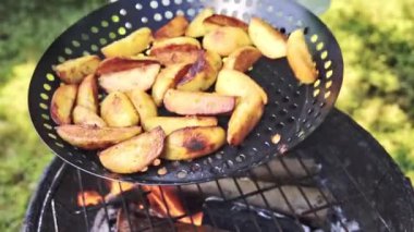 Özel bir ızgara tavasında sebze kızartıyorum. Şef patatesleri kızartır ve tavayı hareket ettirerek karıştırır. Yavaş çekim 100 fp. Yüksek kaliteli FullHD görüntüler