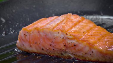 Dökme demir tavada pişen sulu somon bifteğinin yakın çekimi. Sağlıklı beslenme konsepti. Yüksek kalite 4k görüntü