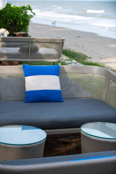 Blue pillow on a comfortable long chair and a relaxing seating set on the beach.