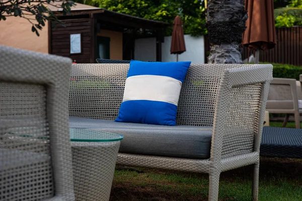 Blue pillow on a comfortable long chair and a relaxing seating set on the beach.