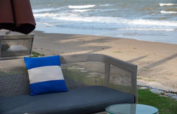 Mavi yastık rahat uzun bir sandalyede ve plajda dinlendirici bir koltuk..