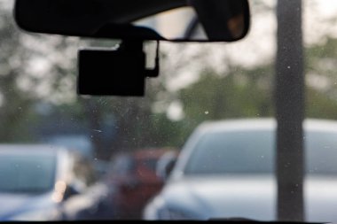 Araba kamerası kayıt için hazır. Bu sırada bir sürücü sabah güzel bir hava koşuluyla otoparktan arabayla uzaklaşmaya hazır..