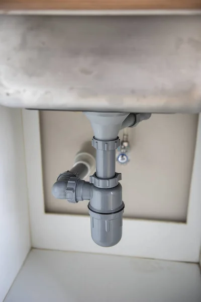 一种铬阀门塞子 连接到厨房水池的塑料排水箱上 — 图库照片