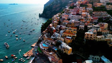 Positano 'nun kıyı cazibesinin muhteşem bir görüntüsü. Uçurumlar ve deniz örnekleri arasında kurulmuş, gök mavisi sulara karşı renkli binalar. Akdeniz cenneti.