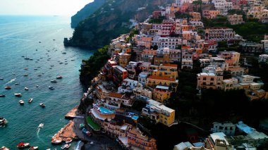 Positano 'nun kıyı cazibesinin muhteşem bir görüntüsü. Uçurumlar ve deniz örnekleri arasında kurulmuş, gök mavisi sulara karşı renkli binalar. Akdeniz cenneti.