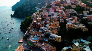 Positano 'nun kıyı cazibesinin muhteşem bir görüntüsü. Uçurumlar ve deniz örnekleri arasında kurulmuş, gök mavisi sulara karşı renkli binalar. Akdeniz cenneti.