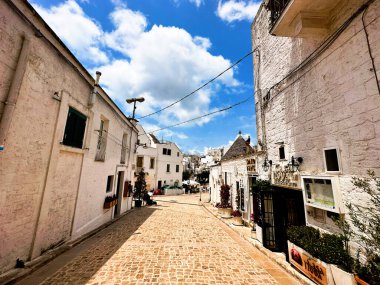 Alberobello 'nun bu fotoğrafıyla bir peri masalı dünyasına adım at. Trulli evleri, konik çatılarıyla, manzarayı güzelleştiriyor, bir sihir hissi uyandırıyor ve Güney İtalya 'nın ebedi cazibesini uyandırıyor..