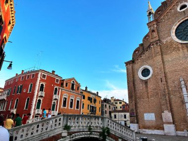 Venedik 'in büyüleyici su yollarının ve zamansız mimarisinin büyüleyici bir görüntüsü. Romantizm içinde yüzen bir şehirde gondolların kemerli köprülerin altında süzüldüğü rüya gibi bir sahne.