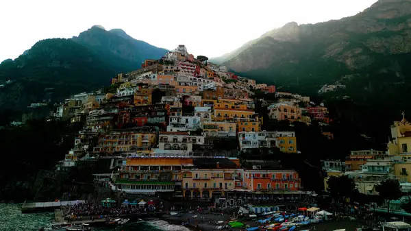 Positano 'nun kıyı cazibesinin muhteşem bir görüntüsü. Uçurumlar ve deniz örnekleri arasında kurulmuş, gök mavisi sulara karşı renkli binalar. Akdeniz cenneti.