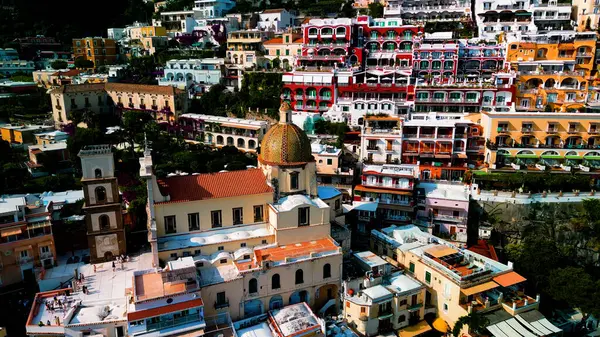 Positano 'nun kıyı cazibesinin muhteşem bir görüntüsü. Uçurumlar ve deniz örnekleri arasında kurulmuş, gök mavisi sulara karşı renkli binalar. Akdeniz cenneti.