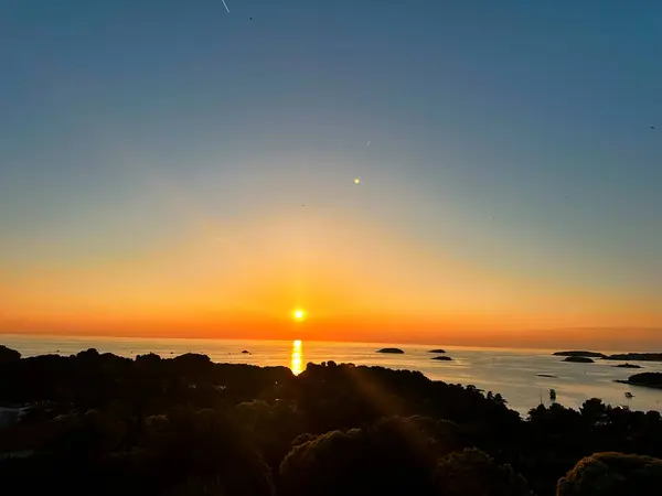 Tek bir karede büyüleyici bir dinginlik, plajda gün batımını yakalayan bir fotoğraf. Gökyüzü sıcacık renklerle parıldıyor. Huzurlu kıyı şeridiyle buluşuyor. Saf bir doğal güzellik ve yansıma anı yaratıyor.