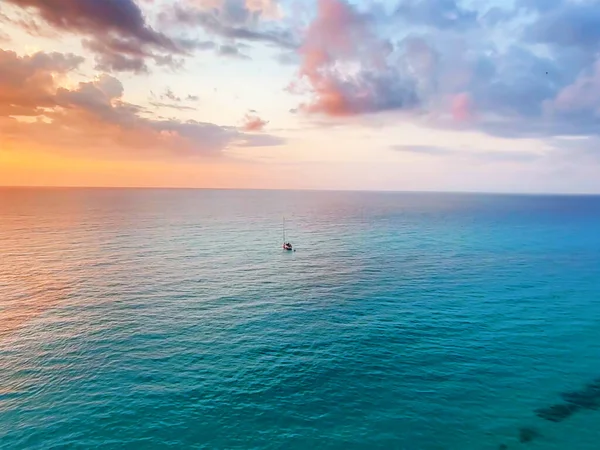 Tek bir karede büyüleyici bir dinginlik, plajda gün batımını yakalayan bir fotoğraf. Gökyüzü sıcacık renklerle parıldıyor. Huzurlu kıyı şeridiyle buluşuyor. Saf bir doğal güzellik ve yansıma anı yaratıyor.