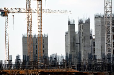 Giza, Mısır, 10 Temmuz 2022: Yeni konut binalarının inşaatı ve vinçlerle yüklenen nesneleri, yüksek gökdelen kulelerini, seçici odaklı kuleleri taşıyan yüksek binalar