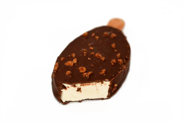 茶色のミルクチョコレートとローストアーモンドの分離割れで豊かなバニラ風味のアイスクリーム バニラアイススティックコーティングされ ナッツとダークチョコレートの層で覆われ 選択的な焦点 — ストック写真