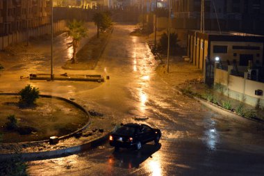 Kahire, Mısır, 25 Ekim 2022: Şiddetli yağmur, gök gürültüsü ve şimşekler nedeniyle Mısır 'ın Kahire kentinde sisli ve belirsiz sokakların manzarası, geceleri sel baskınlarının seçici odak noktası.