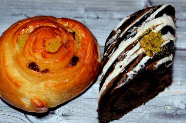 Pişmiş tarçınlı börek, bal ve kuru üzümle tatlandırılmış, kremalı ve çikolatalı pastayla doldurulmuş İsviçre dürümü, hafif çikolatalı süngerli kek ve vanilyalı krema karışımı.