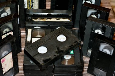 Kahire, Mısır, 18 Ekim 2022: video kaset yığını, video kayıt cihazlarında kullanılan malzeme ve makara ve plastikten yapılmış VHS video kasetleri, modası geçmiş eski video kasetler.