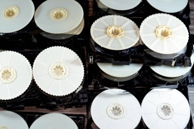 İçeriden video kaset yığını. Ön kaplaması kaldırılmış. Malzemeleri gösteriyor ve video kaydedicilerde kullanılan kurdelelerle makara alıyor.