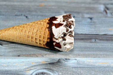 Çikolata parçalı dondurma külahlı dondurma külahı, gevrek külahta erimiş soğuk dondurmanın seçici odak noktası waffle bisküvileri, yaz tatili konsepti.