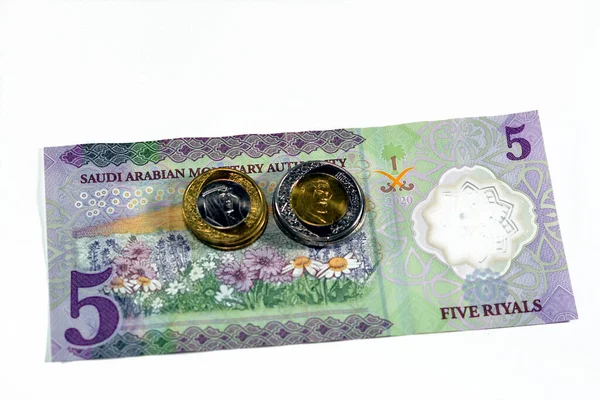 新しい高分子の逆側5 Sar 5サウジアラビアリヤル現金紙幣シリーズ1441 Ahは 選択的フォーカスに隔離された1と2のリヤル硬貨の変化を持つ花のフィールドを備えています — ストック写真